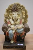 A decorative cast resinous figure of the Hindu deity Ganesh, seated 28cm