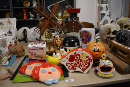 An assortment of vintage items including a Snoopy piggy bank, a Jim'll fixt ceramic mug and a