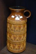 A large West German pottery vase decorated with geometric patterns on a brown glazed ground, model