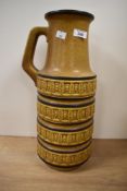 A large vintage West German vase with handle, having geometrical patterns on a mustard ground,