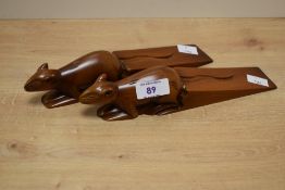 A pair of carved wooden rodent form door wedges, 23cm