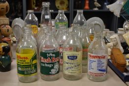 A group of twenty one vintage milk bottles having various advertisements including Ty-Phoo Fresh