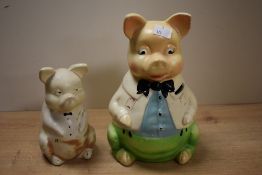 A pair of mid-century ceramic piggy banks, modelled as comical father pig and baby pig, hand