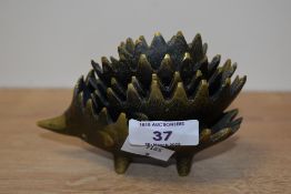 A graduating set of 6 vintage hedgehog brass ashtrays, stackable with spike backs, largest L12cm
