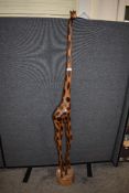 A large African carved wood giraffe study, with burnt coloured markings and circular base 155cm