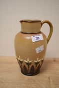 A late 19th century Doulton Lambeth stoneware pitcher in the Arts and Crafts style, partly decorated