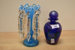 An eye catching iridescent glass bottle, with globular stopper over flared rim and ovoid body,