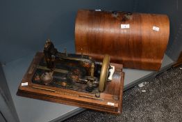 An early 20th century singer sewing machine having original ceramic handle and case, the machine