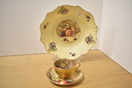 A hand painted Royal Worcester cup and saucer decorated with fallen fruit, cup signed