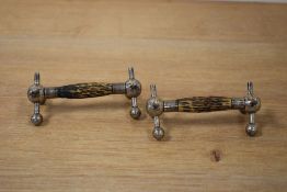 A pair of white metal and antler knife rests, of traditional form having central antler bars, raised