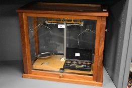 An early 20th century Towers Widnes scientific weighing scale, housed in a wooden display case,