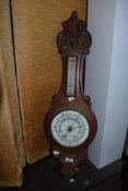 A Aneroid Barometer having temperature gauge in both Fahrenheit and centigrade, the oak case