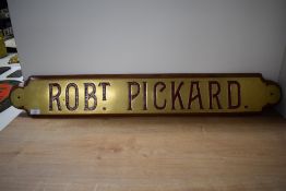 A brass Railway style Name Plate, ROBt PICKARD on mahogany mount, 104cm x 16cm