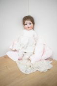 A early 20th century Simon Halbig bisque headed Doll having sleep blue eyes, open mouth with two