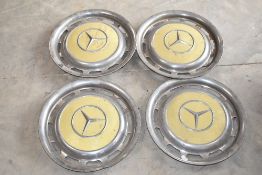 A set of vintage Mercedes wheel trims