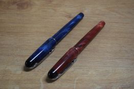 Two Waterman Phileas rollerball pens in Red Laque and Blue Laque with chrome trim, some