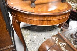 A continental style oval dining table, having quarter veneer and inlay style top, with applique