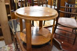 An early 20th Century golden oak coffee table of circular form with undertier, diameter approx.