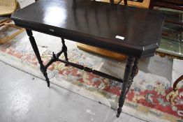 A Victorian mahogany side table having canted corner top on turned frame and castors, approx. 91 x