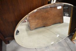 A frameless wall mirror of oval form approx. 76 x 51cm