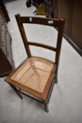 A 19th Century stained frame bedroom chair having bergere canework seat