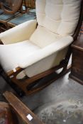 A vintage teak framed designer rocking chair, in the 'paper knife' style, attributed to Kai