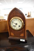 An Edwardian mahogany mantle clock of bishops mitre form, with enamelled face and foilate
