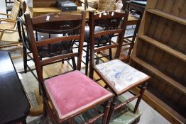 A pair of Victorian mahogany bedroom chairs having later upholstery to seats
