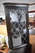 A traditional dark stained corner display cabinet