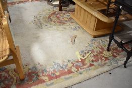 A vintage room sized carpet square having cream ground