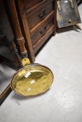 A traditional copper and brass bed warming pan