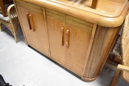 An Art Deco golden oak sideboard, having cupboard storage to ends, width approx. 135cm