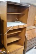 A vintage laminate teak effect wall unit of narrow proportions