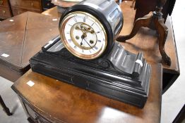 A Victorian black slate mantel clock having visible movement with enamelled roman numeral dial