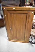 A 19th Century oak corner cupboard , in a light stain, height approx. 121cm