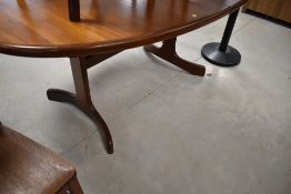 A mid Century teak G plan extending dining table of oval form having 'whale tail' style legs,