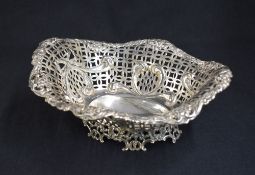 An impressive late Victorian silver fruit bowl, of oval form having a curved flared scroll rim,