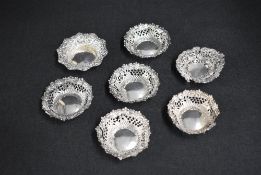 A group of seven Victorian silver pin dishes, all having decorative floral scroll rims and six
