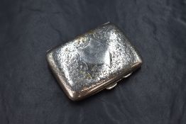 A late Edwardian silver cigarette case of hinged rectangular form slightly curved for the