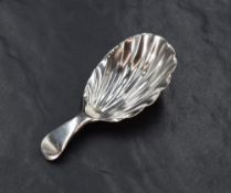 A Georgian silver caddy spoon, of traditional form having a scallop bowl and plain terminal,
