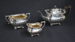 An Edwardian silver three piece tea set, comprising a tea pot, cream and sugar, of rectangular