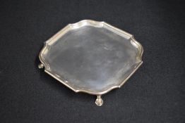 A George VI silver salver, of square form having a Chippendale style rim, raised on four hoof