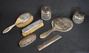 A George V silver mounted vanity set, comprising a hair brush, a clothes brush, comb, a mirror,