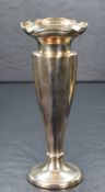 A George V silver fluted vase, having a flared Chippendale style rim and canted body, raised on a