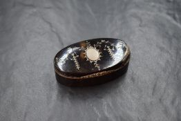 A 20th century white metal inlaid tortoiseshell trinket box, of hinged oval form having a vacant