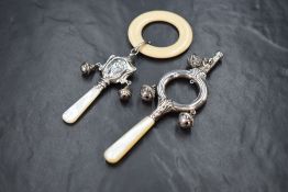 An Edwardian silver babies' rattle, of circular form having embossed decoration and three bells,