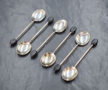 A cased set of six George V silver coffee bean spoons, having black 'beans' to the terminals,