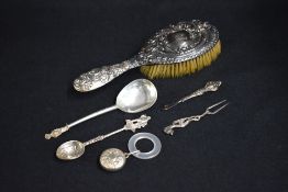 An Edwardian silver mounted hair brush, having embossed scroll decoration with 'ML' monogram to