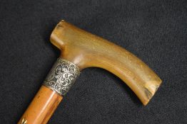 A Victorian silver mounted walking stick, the wooden cane with curved horn handle, having decorative