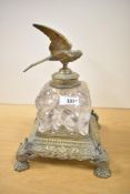 A Victorian cast brass and glass ink well, mounted on an exuberant base having paw feet and stylised